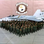 Army Military lined up in front of a fighter jet